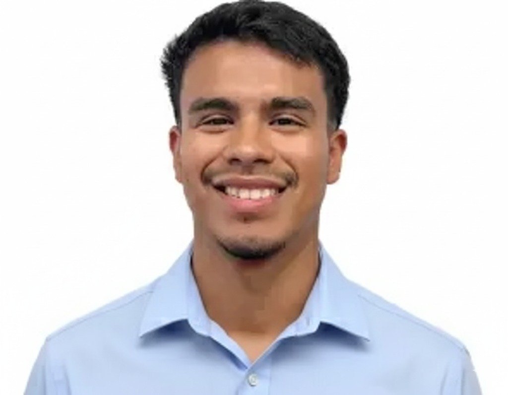 Smiling person in a black shirt, against a white background.